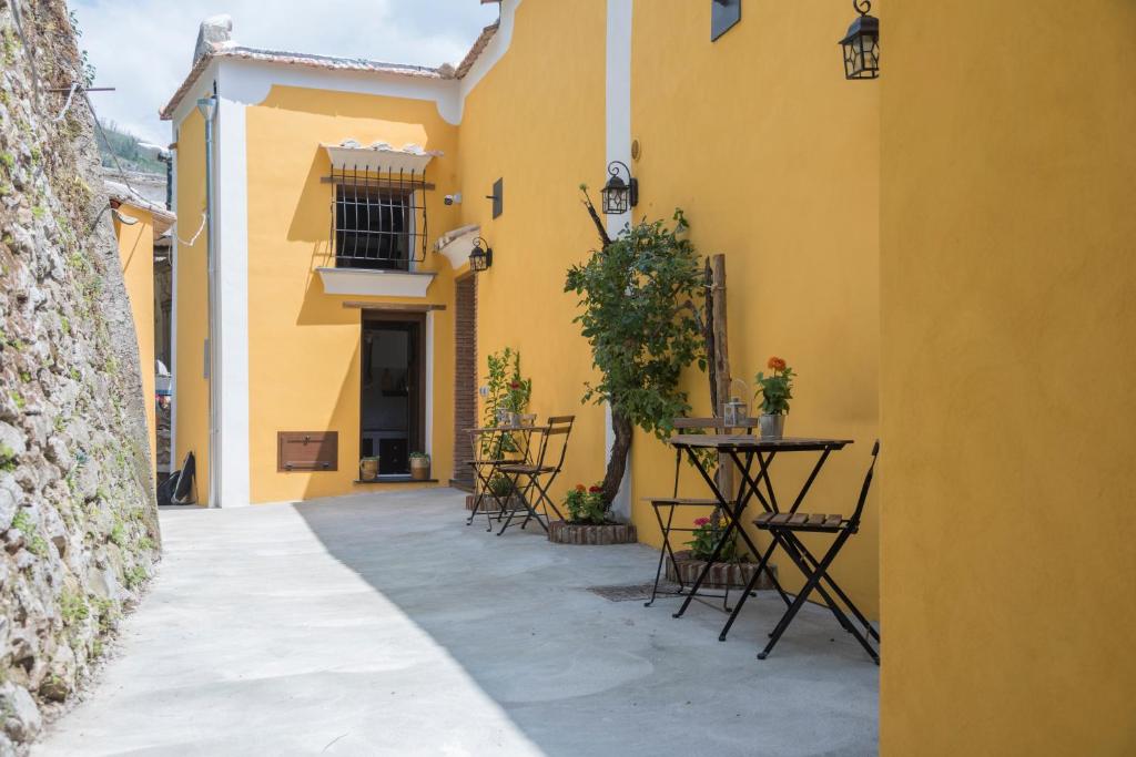 トラモンティにあるTRA... INCANTO E NATURAの黄色い建物内のテーブルと椅子のある路地