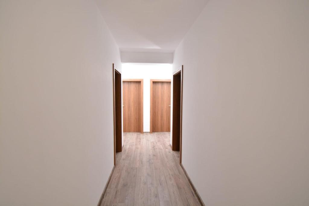 an empty corridor with white walls and wooden doors at Vila La Matache in Eforie Nord