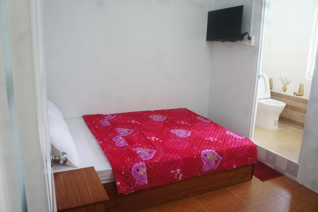 una manta roja sentada en una cama en una habitación en BangBang Motel en Can Tho