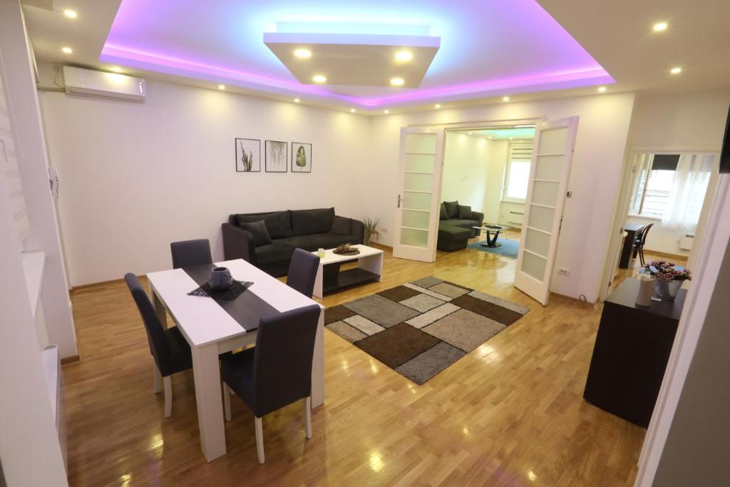 a living room with a table and a purple ceiling at De Luxe Republic Square Apartment of 100sqm in Belgrade