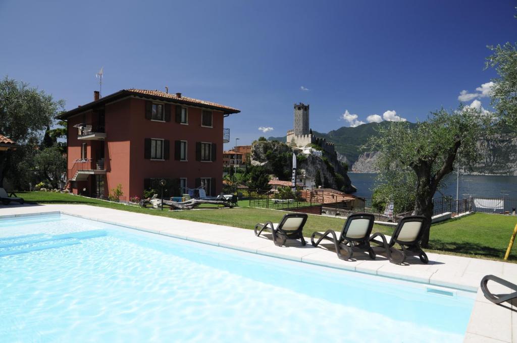 - une piscine avec 2 chaises et une maison dans l'établissement Casa Guarnati Lake View Apartments, à Malcesine