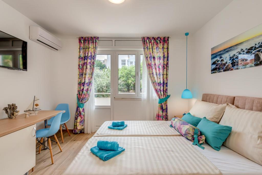 Un dormitorio con una cama y un escritorio y una ventana. en Coloured rooms, en Split