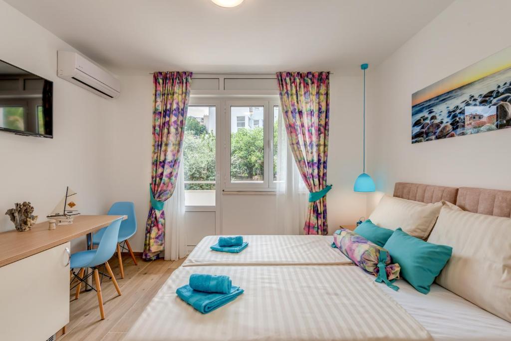 een slaapkamer met een bed, een bureau en een raam bij Coloured rooms in Split