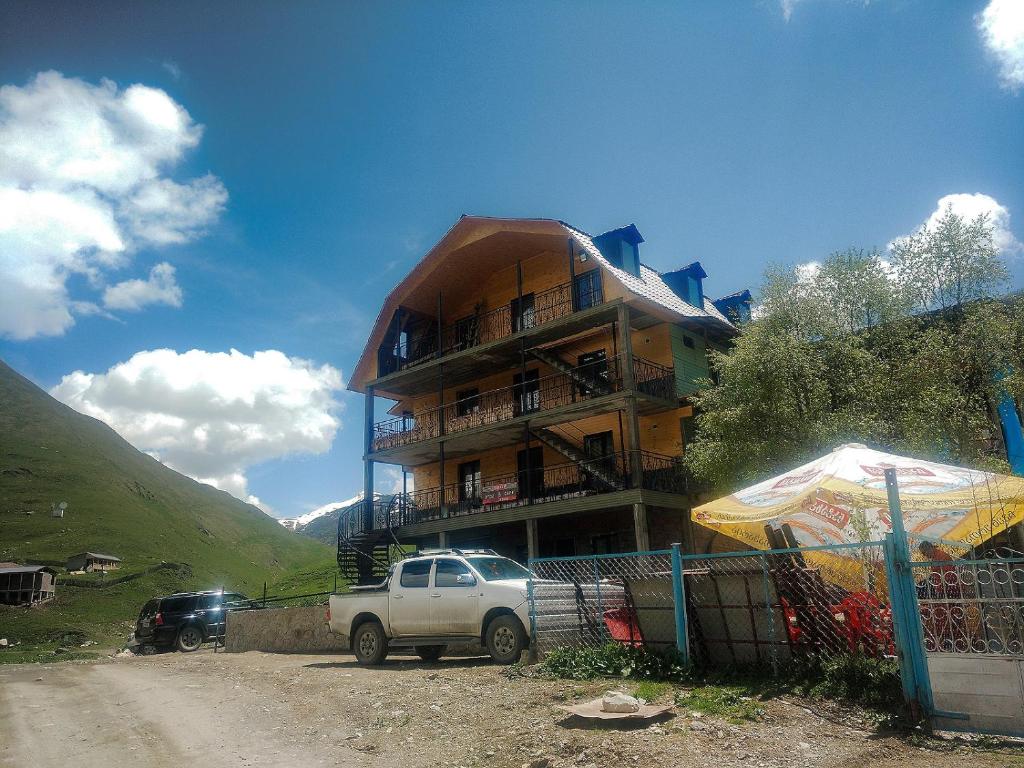 ein LKW, der vor einem Gebäude parkt in der Unterkunft Ushguli Panorama Guest House in Uschguli