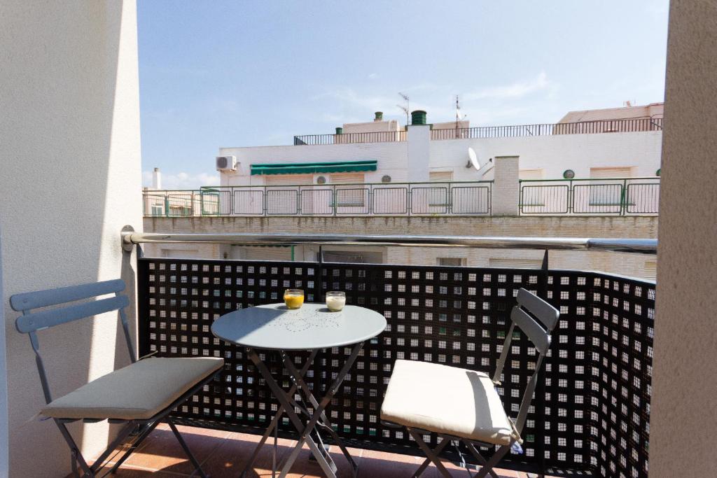 stół i krzesła na balkonie z widokiem na budynek w obiekcie INNOUTHOME Apartamento Ramón y Cajal II w mieście L'Ametlla de Mar