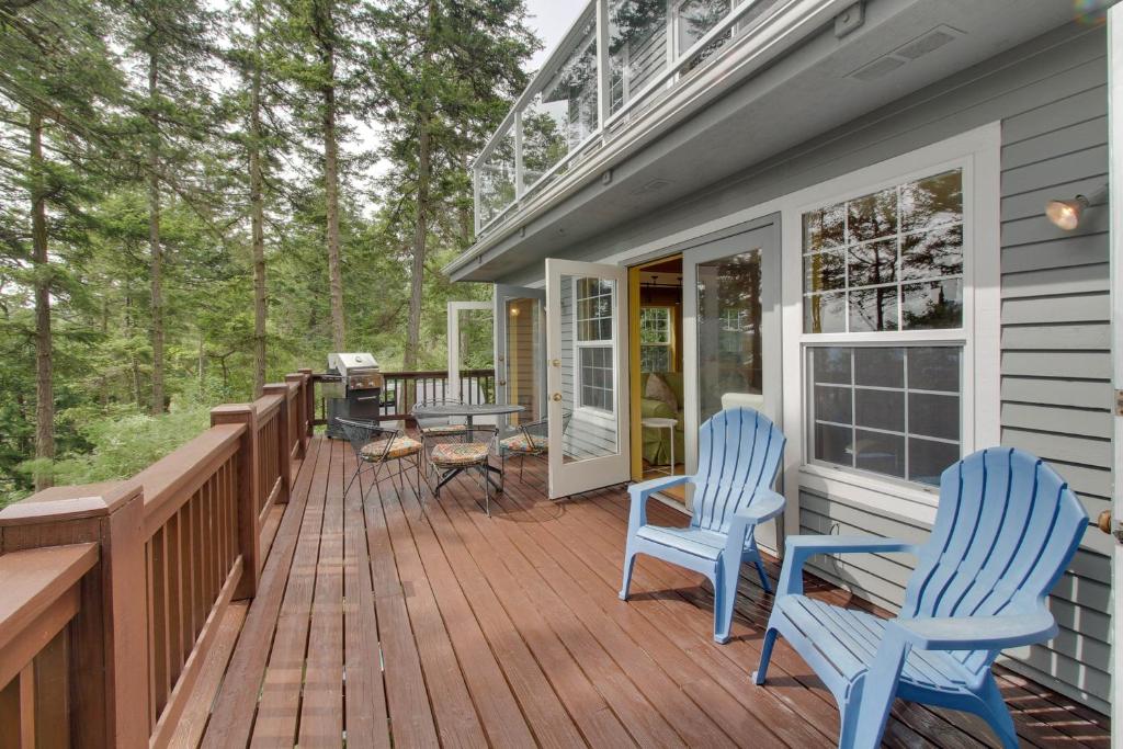 eine Terrasse mit zwei blauen Stühlen auf einem Haus in der Unterkunft Shore Thing Retreat in Eastsound
