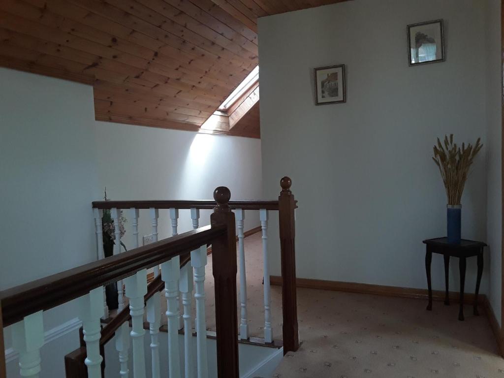 a staircase in a house with a wooden ceiling at Greenmount Accommodation in Killarney