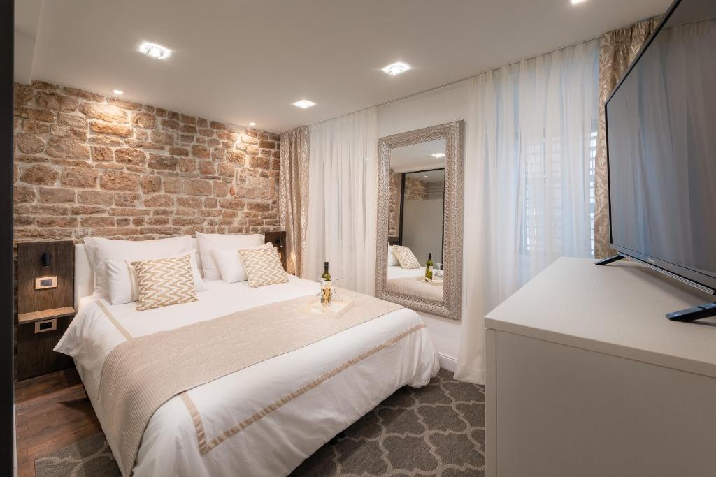 - une chambre avec un grand lit et un miroir dans l'établissement Ziggy Star in Diocletian Palace, à Split
