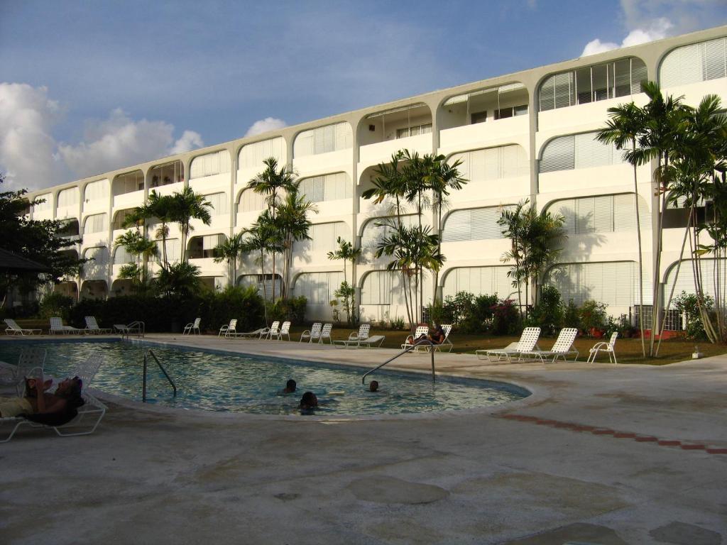 un bâtiment avec une piscine en face d'un bâtiment dans l'établissement Condominium 220, à Saint James