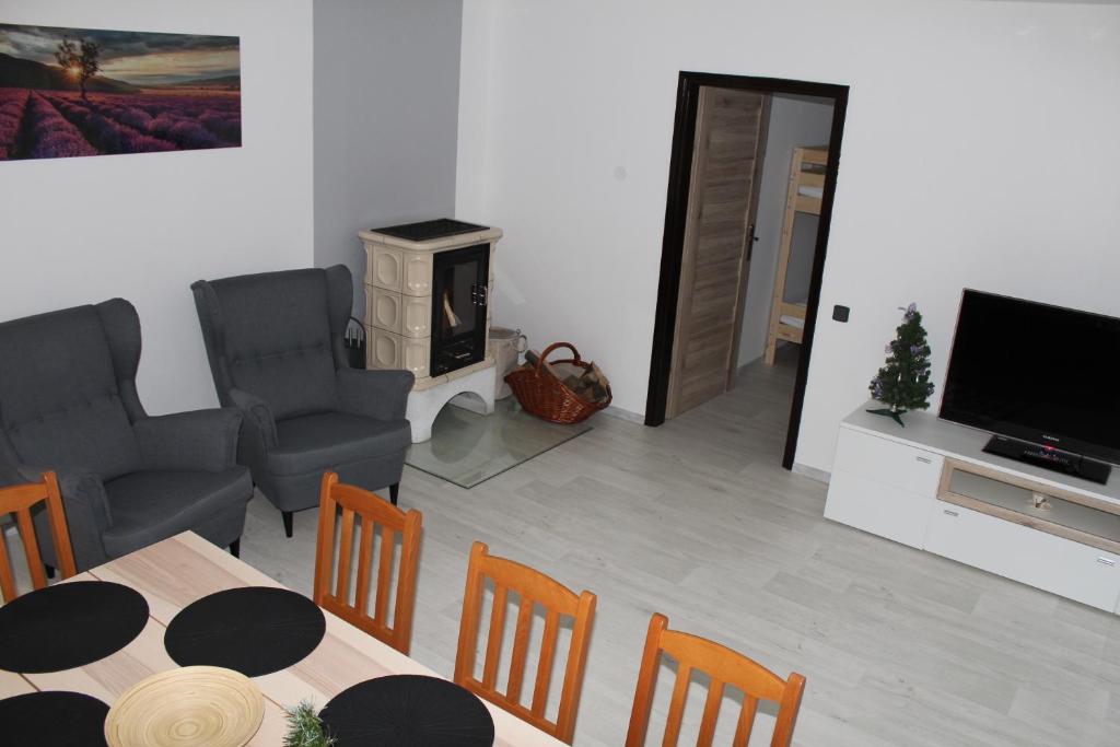 a living room with a table and chairs and a television at Vila Marianna in Deštné v Orlických horách