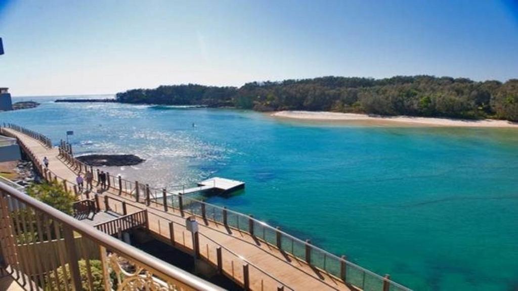 a bridge over a river with a boat in the water at Kingscliff Waters Apartment 5 in Kingscliff