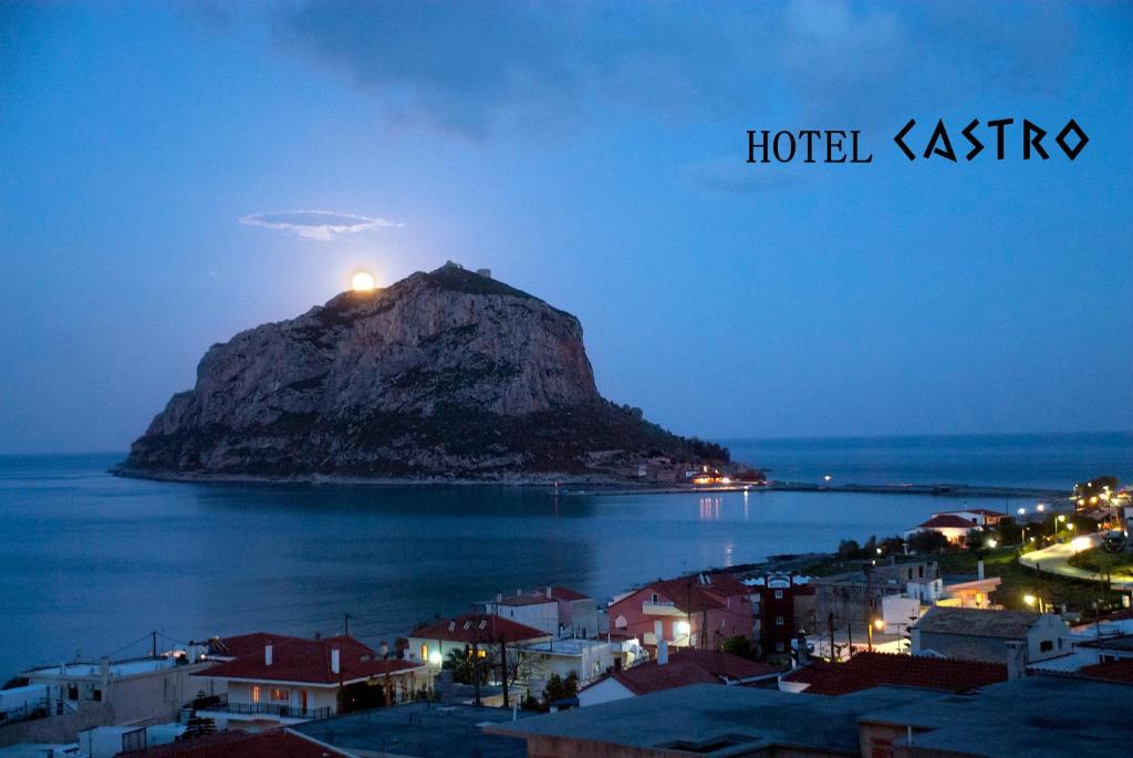 a view of a mountain in the water at night at Castro Hotel in Monemvasia