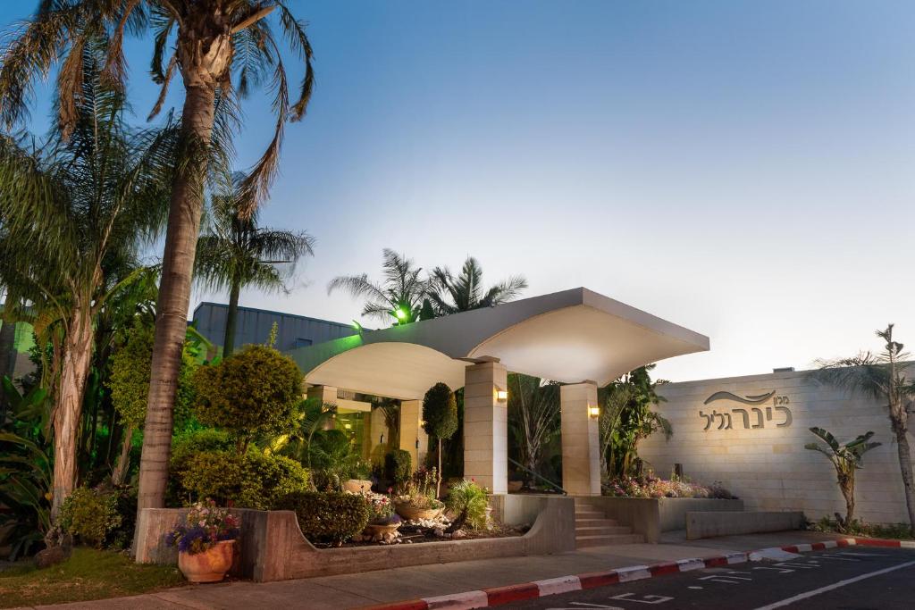 um edifício com uma palmeira em frente em Kinar Galilee em Kinar