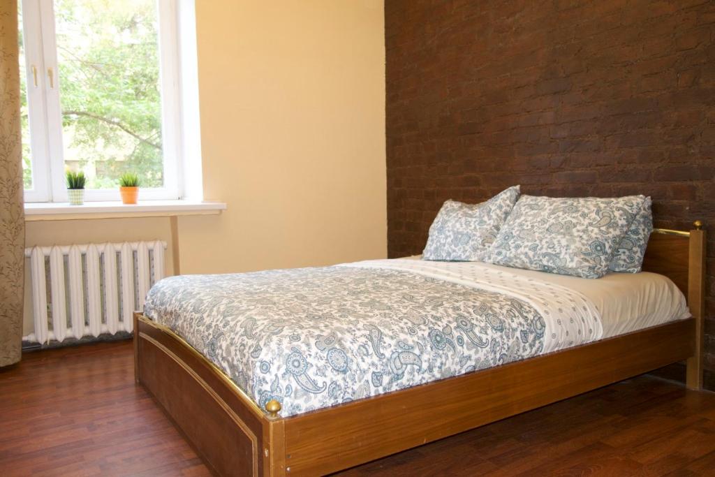 1 cama en un dormitorio con pared de ladrillo en KvartiraSvobodna - Apartment at Pervy Basmannyy Pereulok, en Moscú