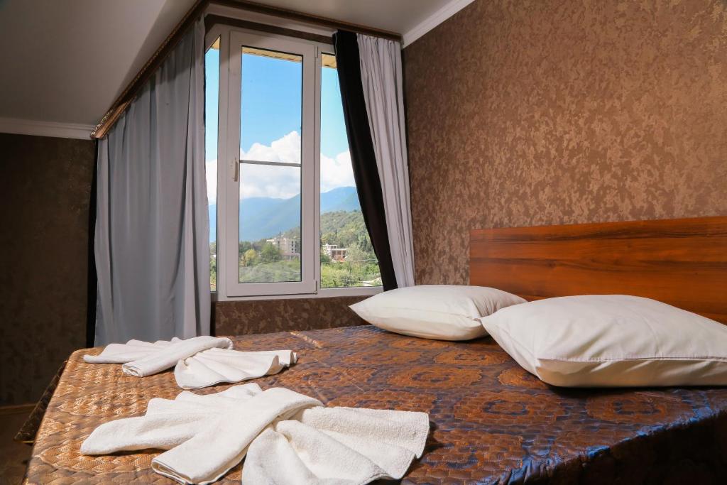a bedroom with two beds with white towels on them at Bon Amour in Gagra