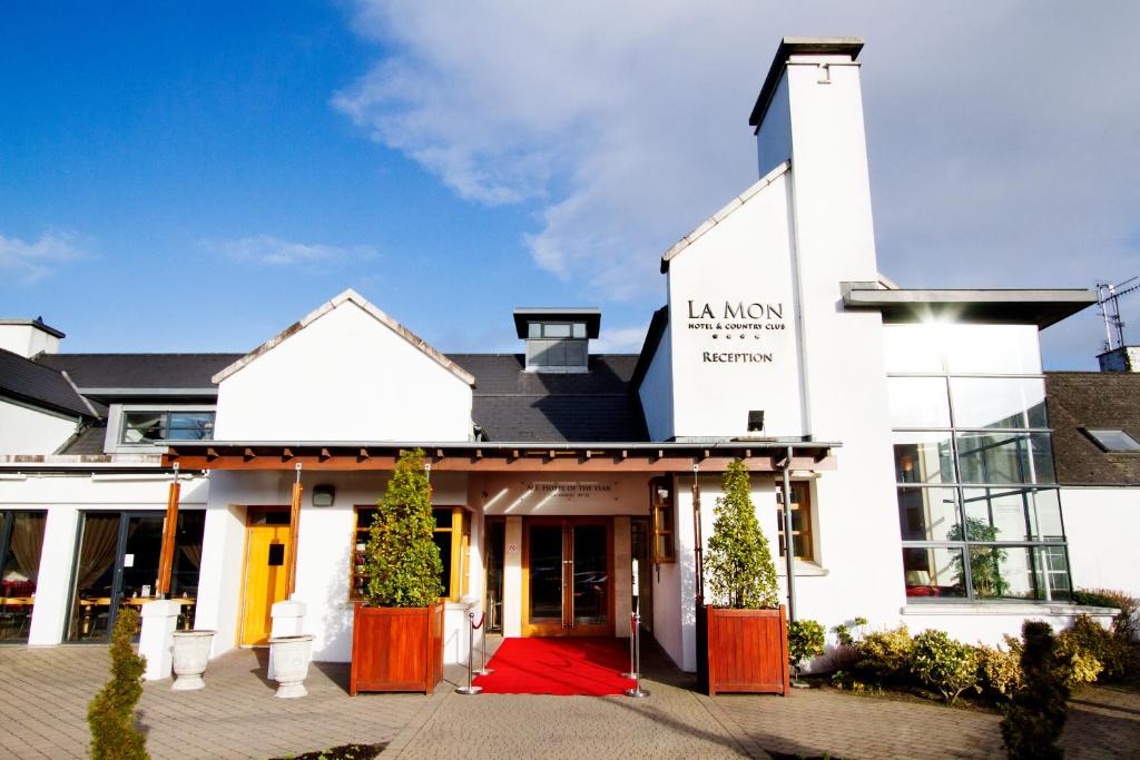 a white building with the front entrance to la maison restaurant at La Mon Hotel & Country Club in Castlereagh