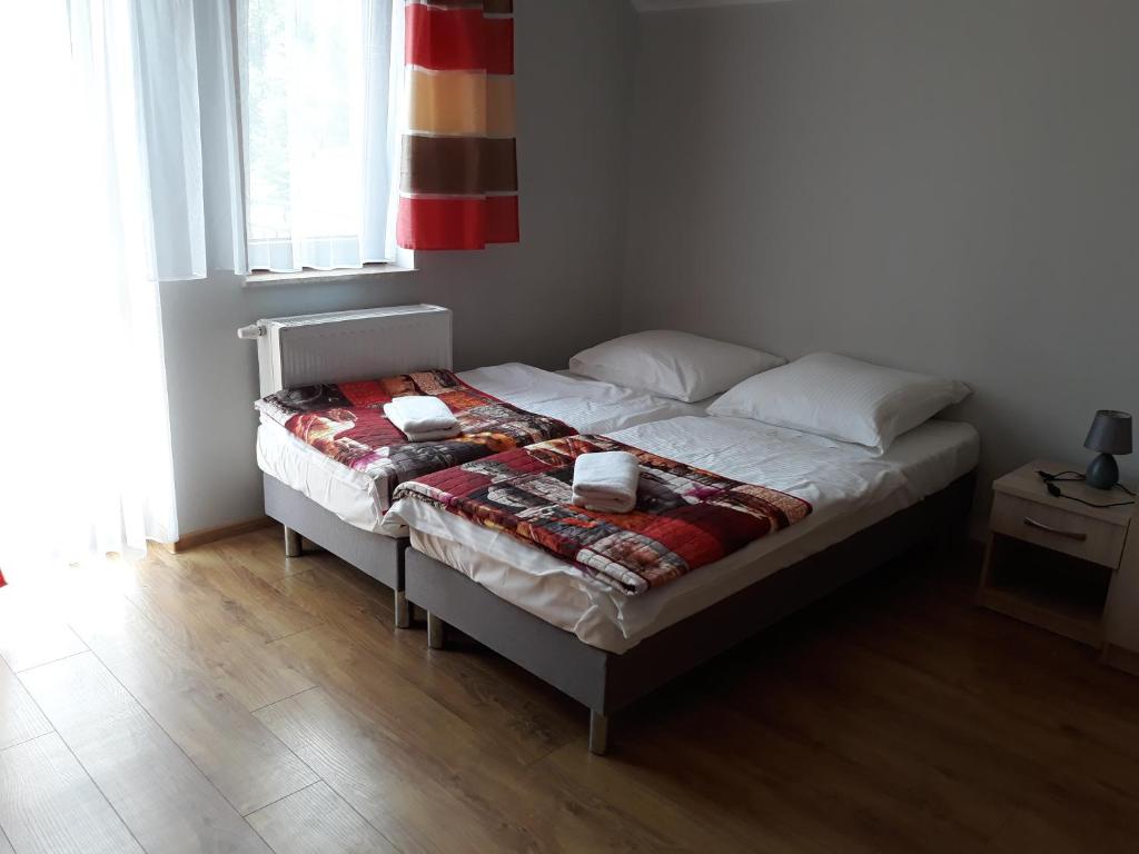 een bed met een deken erop in een slaapkamer bij Pokoje Gościnne Maczek in Sztutowo