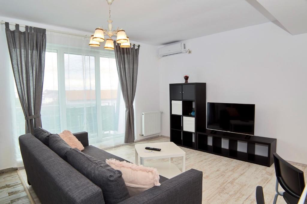a living room filled with furniture and a tv at Denisa Apartamente in Otopeni