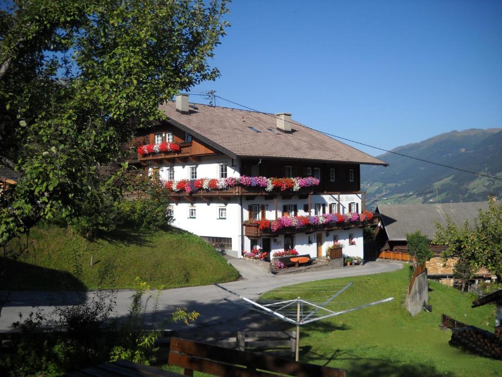 ein großes weißes Gebäude mit Blumen auf den Balkonen in der Unterkunft Gästehaus Maria in Kartitsch