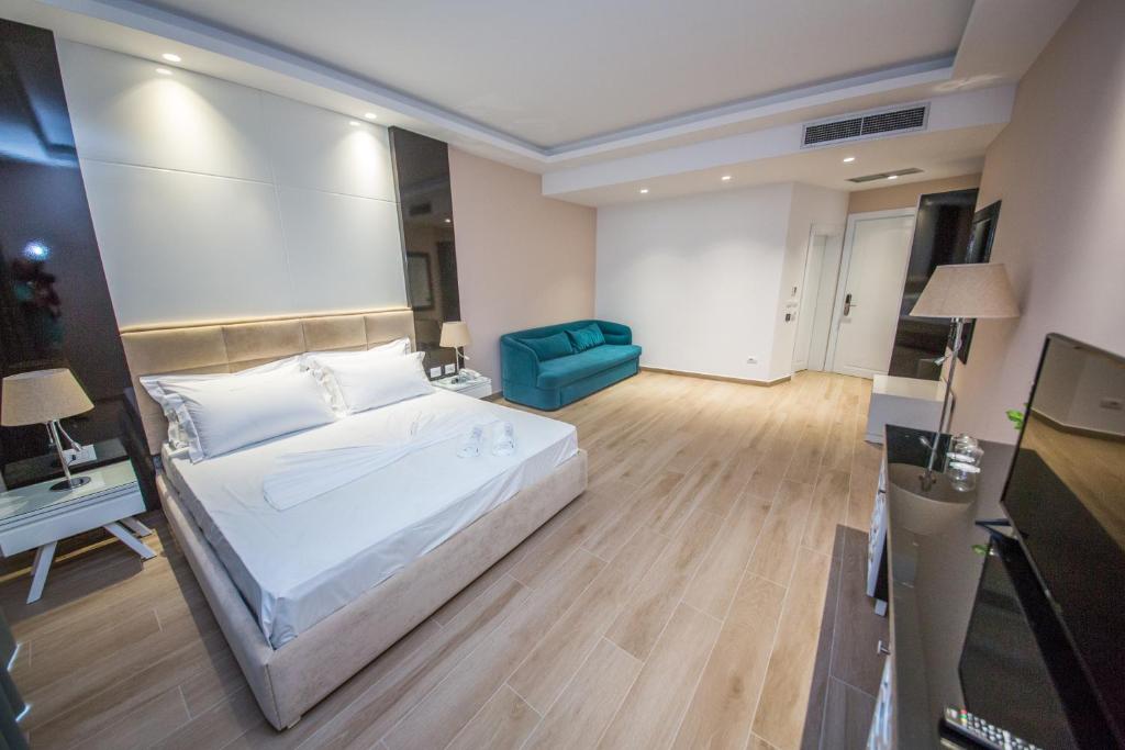 a large bedroom with a bed and a blue couch at Sole Luna Hotel in Borsh