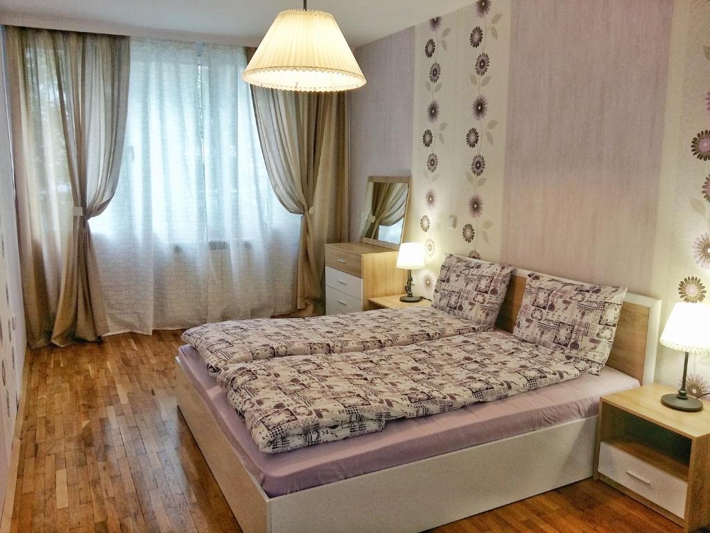 a bedroom with a bed and a large window at Fresh Apartment in Sofia
