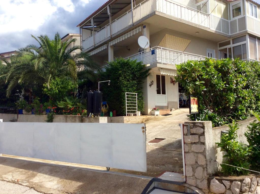 a white fence in front of a house at Apartment Stula in Omišalj