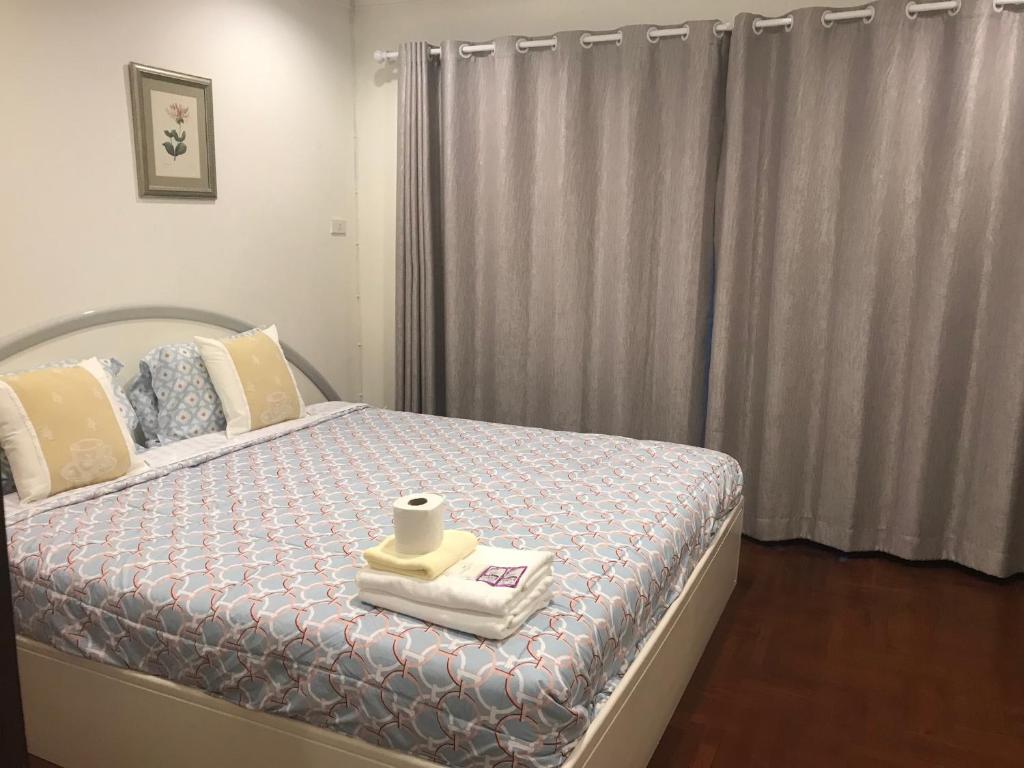 Un dormitorio con una cama con un rollo de papel higiénico. en Nineplace 46, en Bangkok