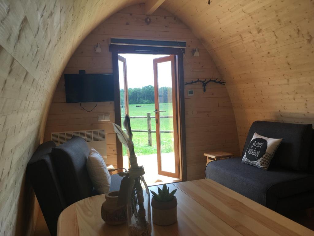 a room with a couch and a table and a window at De Rozephoeve Studio in Oisterwijk