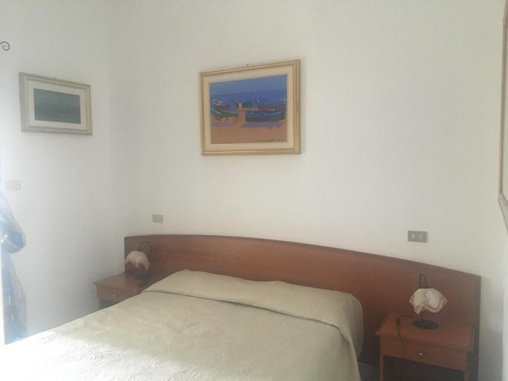 - une chambre avec un lit et une photo sur le mur dans l'établissement Locanda Al Castello, à Peschici