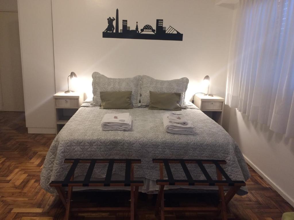 una camera con un letto con due tavoli e due lampade di Luminoso Estudio a Buenos Aires