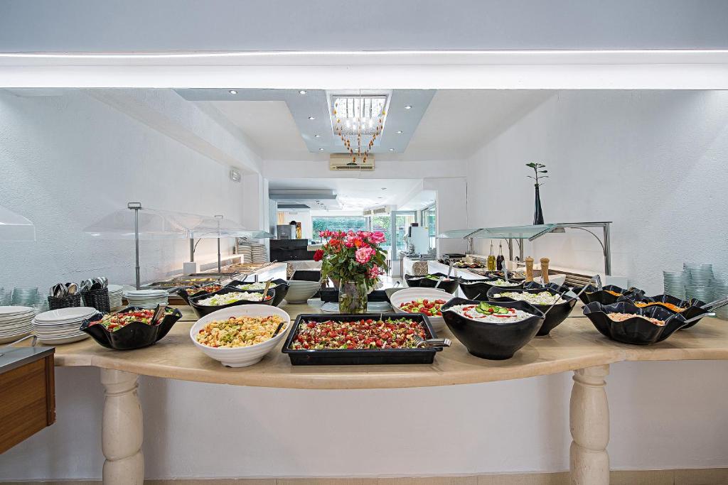 a table with many bowls of food on it at South Coast Hotel in Makry Gialos