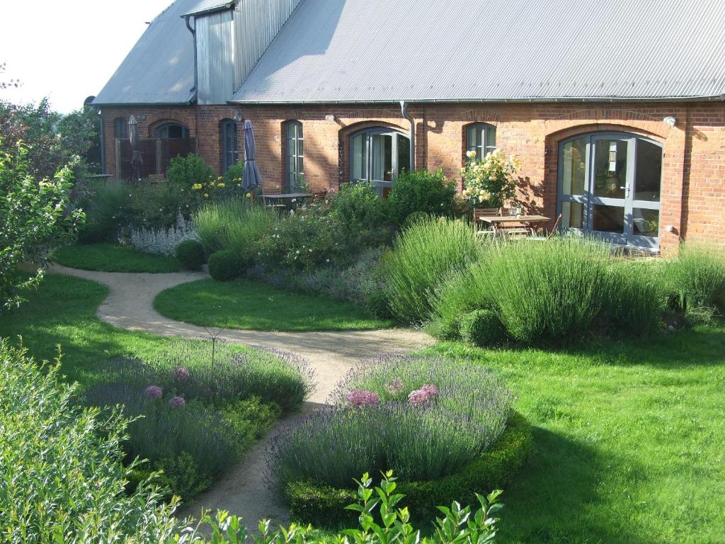 einen Garten mit einem Backsteinhaus und einem Pfad in der Unterkunft Birkenhof an der Ostsee in Hohenkirchen