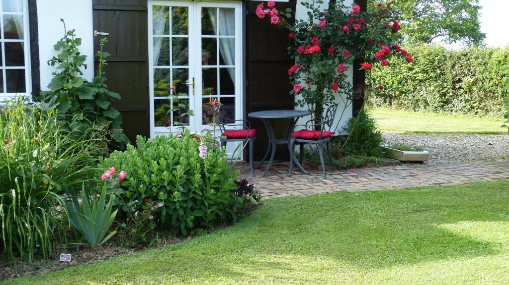 una casa con mesa y sillas en un jardín en Le Petit Verger, en Grumesnil
