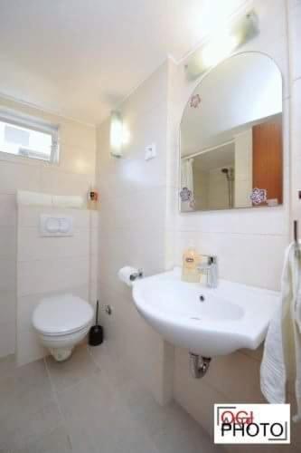 a bathroom with a sink and a toilet and a mirror at Apartments Marcela in Stari Grad