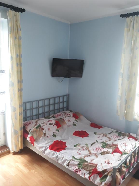 a bedroom with a bed with flowers on it at Uniejów Pensjonat Pod Miłorzębem in Uniejow