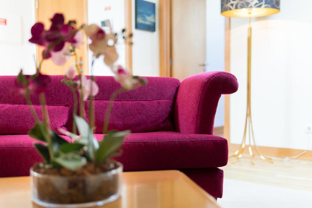 um sofá roxo sentado numa sala de estar com uma mesa em Aguia - T1 By RMC no Funchal