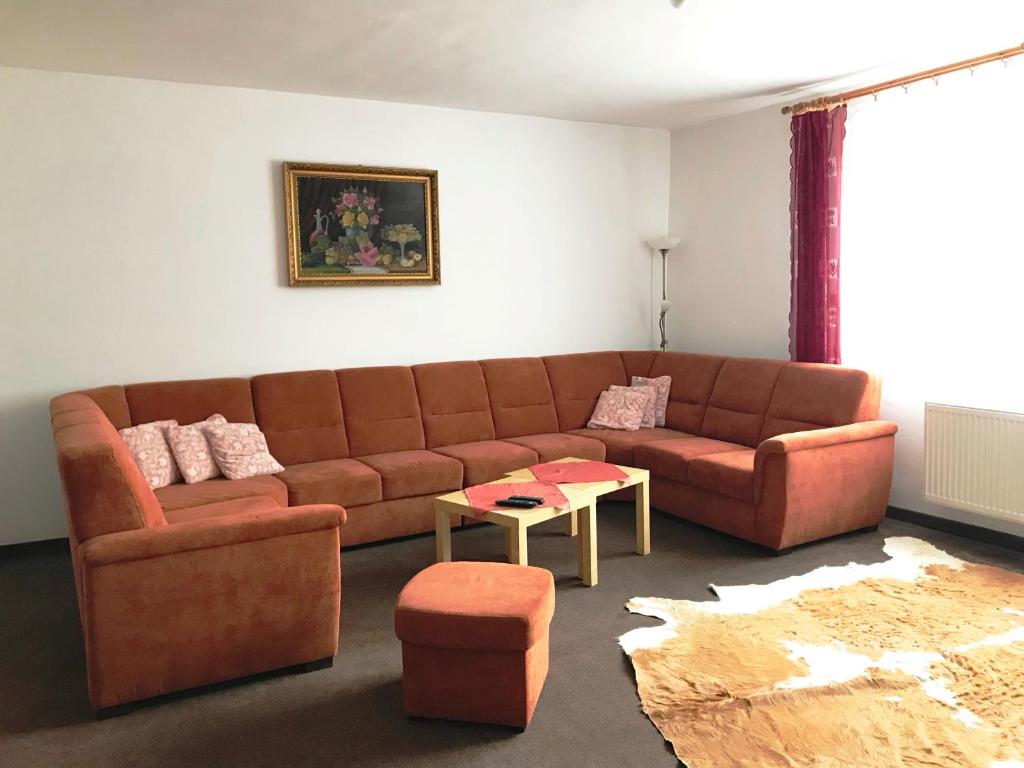 ein Wohnzimmer mit einem braunen Sofa und einem Tisch in der Unterkunft Sunnystreet Guesthouse in Stará Lesná