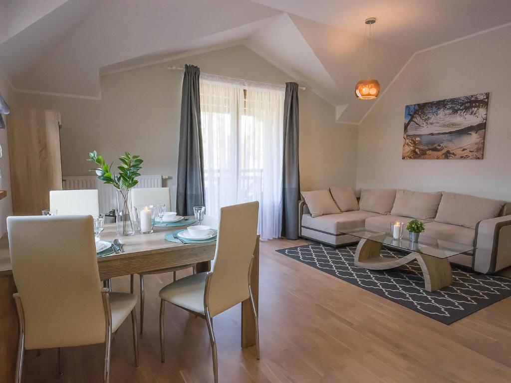 sala de estar con mesa y sofá en VacationClub - Rezydencja Park Apartament 30 en Mielno