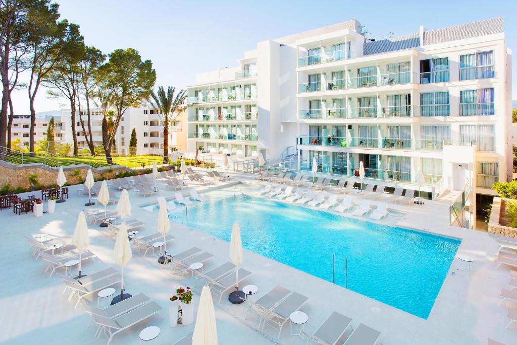 un'immagine di una piscina con sedie e di un edificio di Reverence Life Hotel - Adults Only a Santa Ponsa