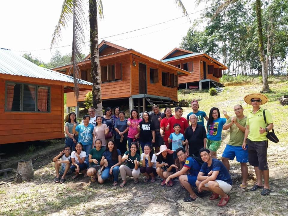 a group of people posing for a picture in front of a house at Long Titi Homestay in Sematan