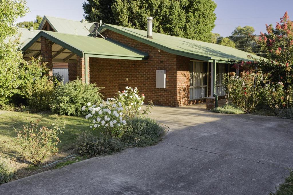 a brick house with a green roof and a driveway at Monty's on Lumley Drive in Bright