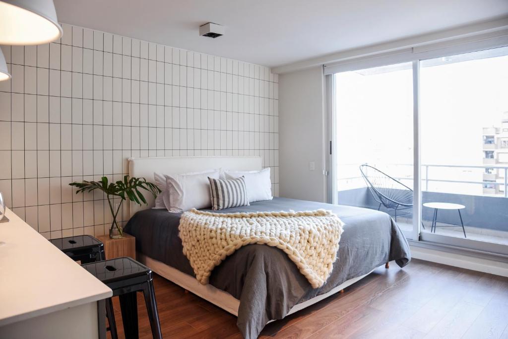 um quarto com uma cama e uma grande janela em Top Rentals Nuñez em Buenos Aires