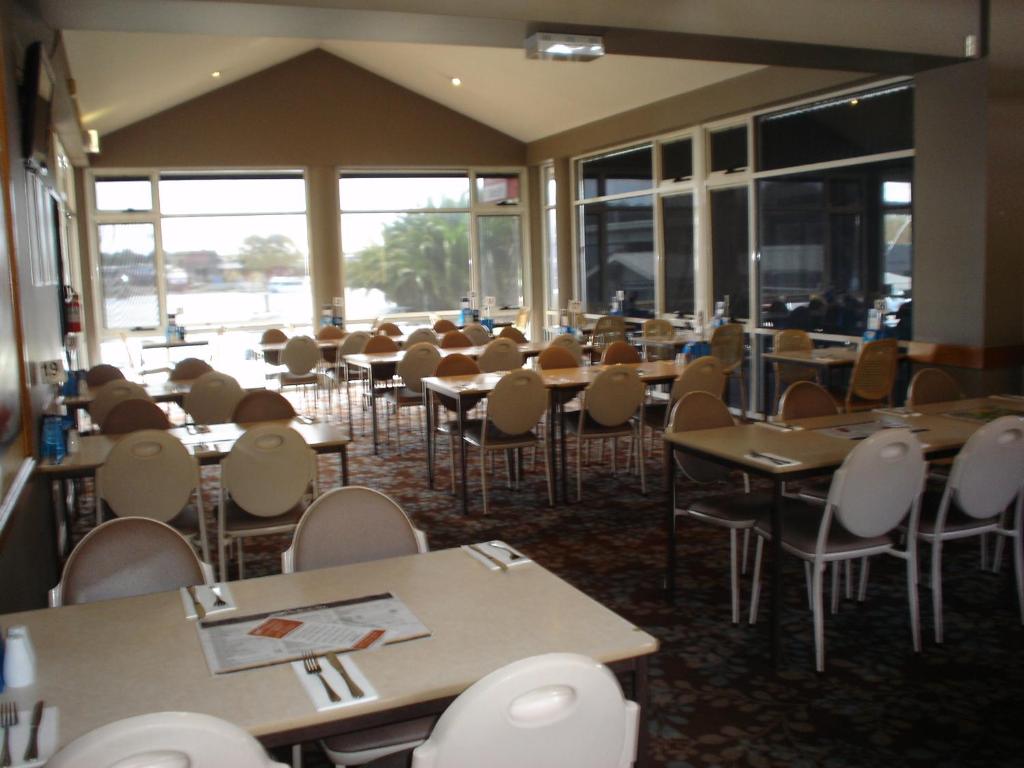 an empty dining room with tables and chairs at Argosy Motor Inn in Devonport