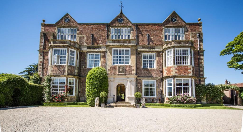 uma grande casa de tijolos com uma grande entrada em Goldsborough Hall em Knaresborough