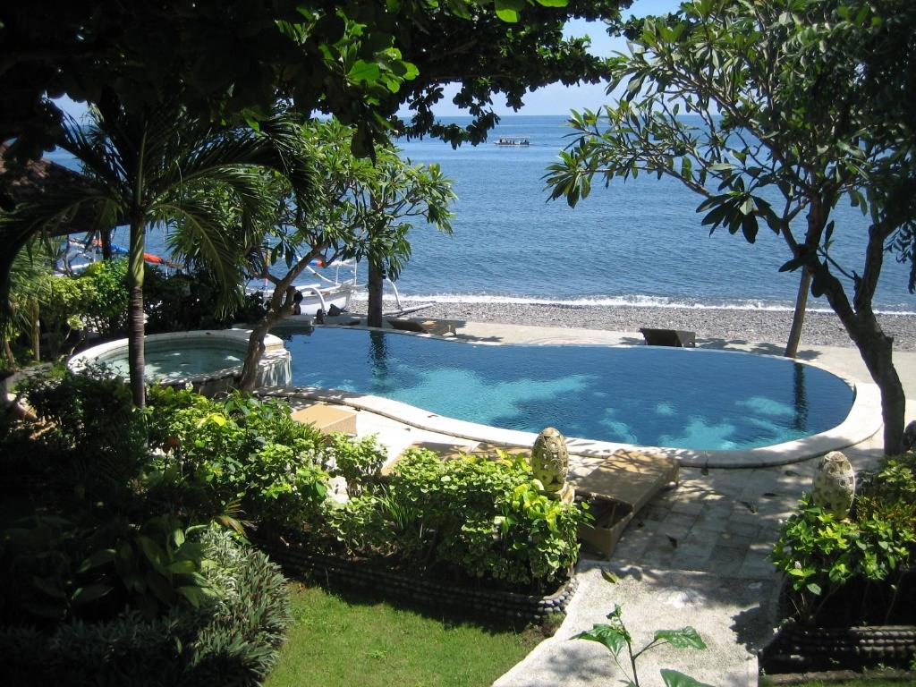 a large swimming pool next to the ocean at Double One Villas in Amed