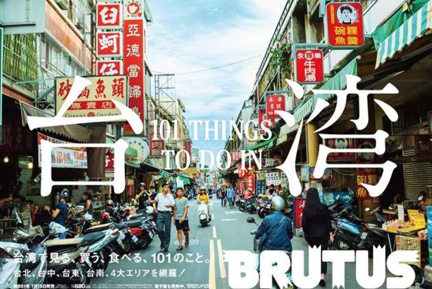 un poster di una strada cittadina con persone e motociclette di REST backpacker a Tainan