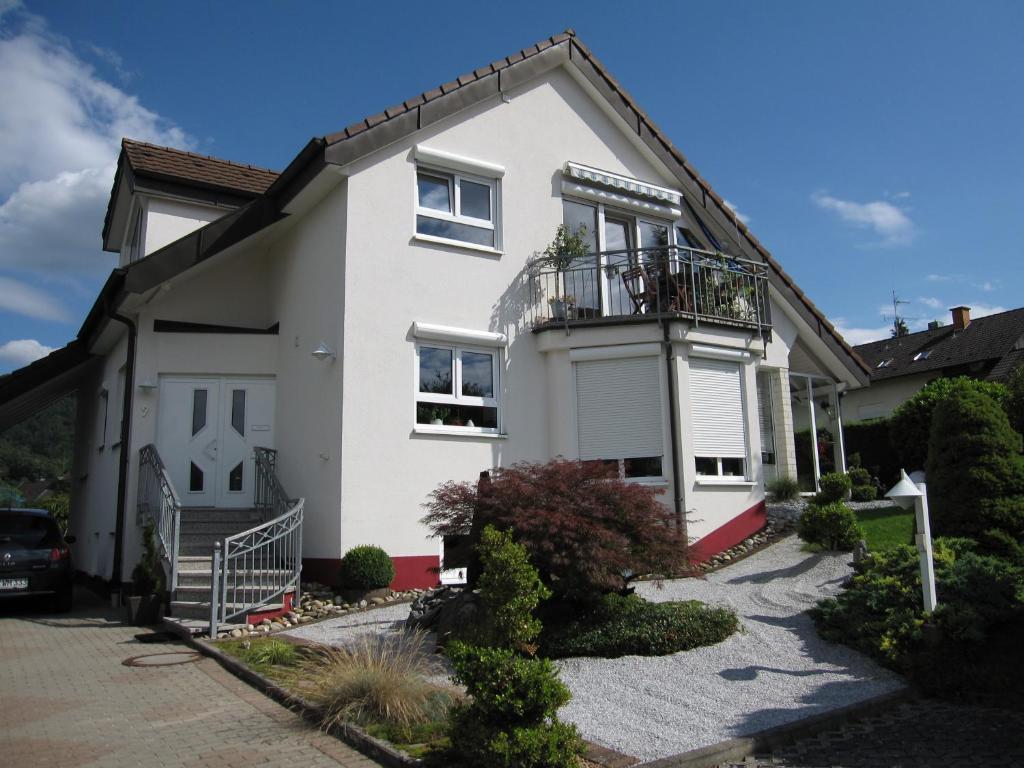 een wit huis met een balkon bij Ferienwohnung Wölfle in Friesenheim