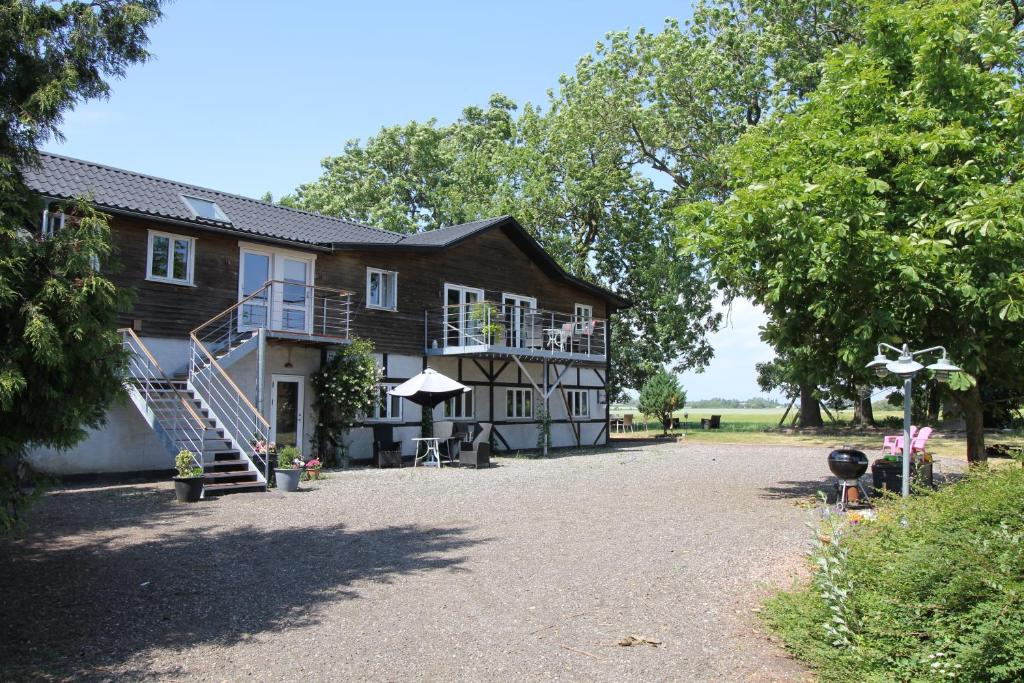 a large house with a porch and stairs leading up to it at Askegaarden Apartments in Sandved