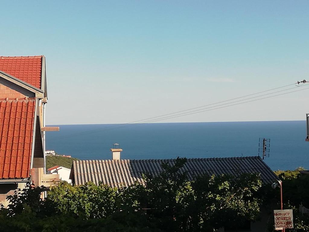 a view of roofs of buildings with the ocean in the background at apartman holiday budva in Budva