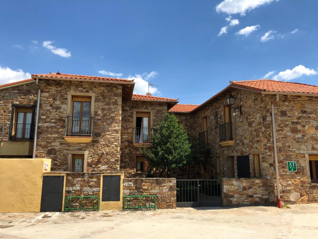 un antiguo edificio de piedra con una puerta delante de él en El Bulín de Piñuecar, en Piñuécar